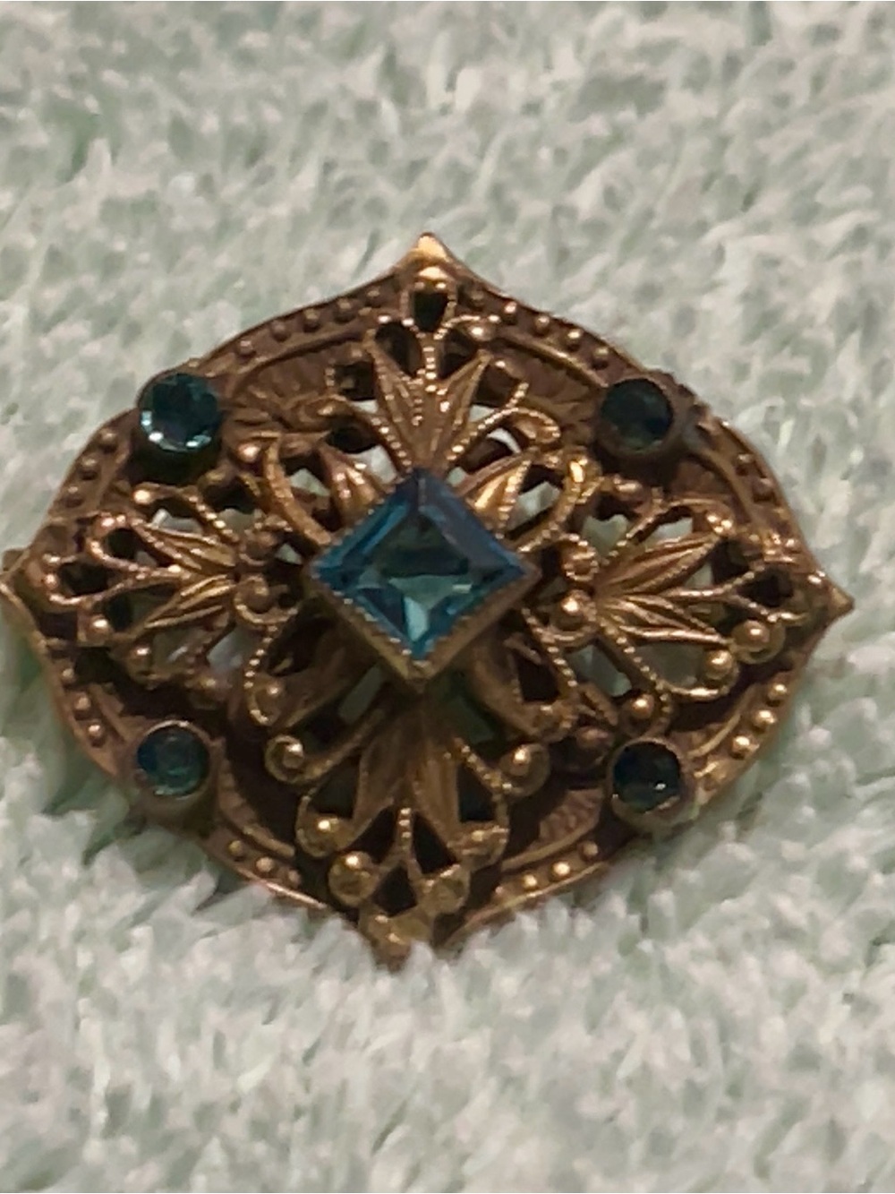 vintage gold-tone filigree brooch with striking Teal crystal stones.